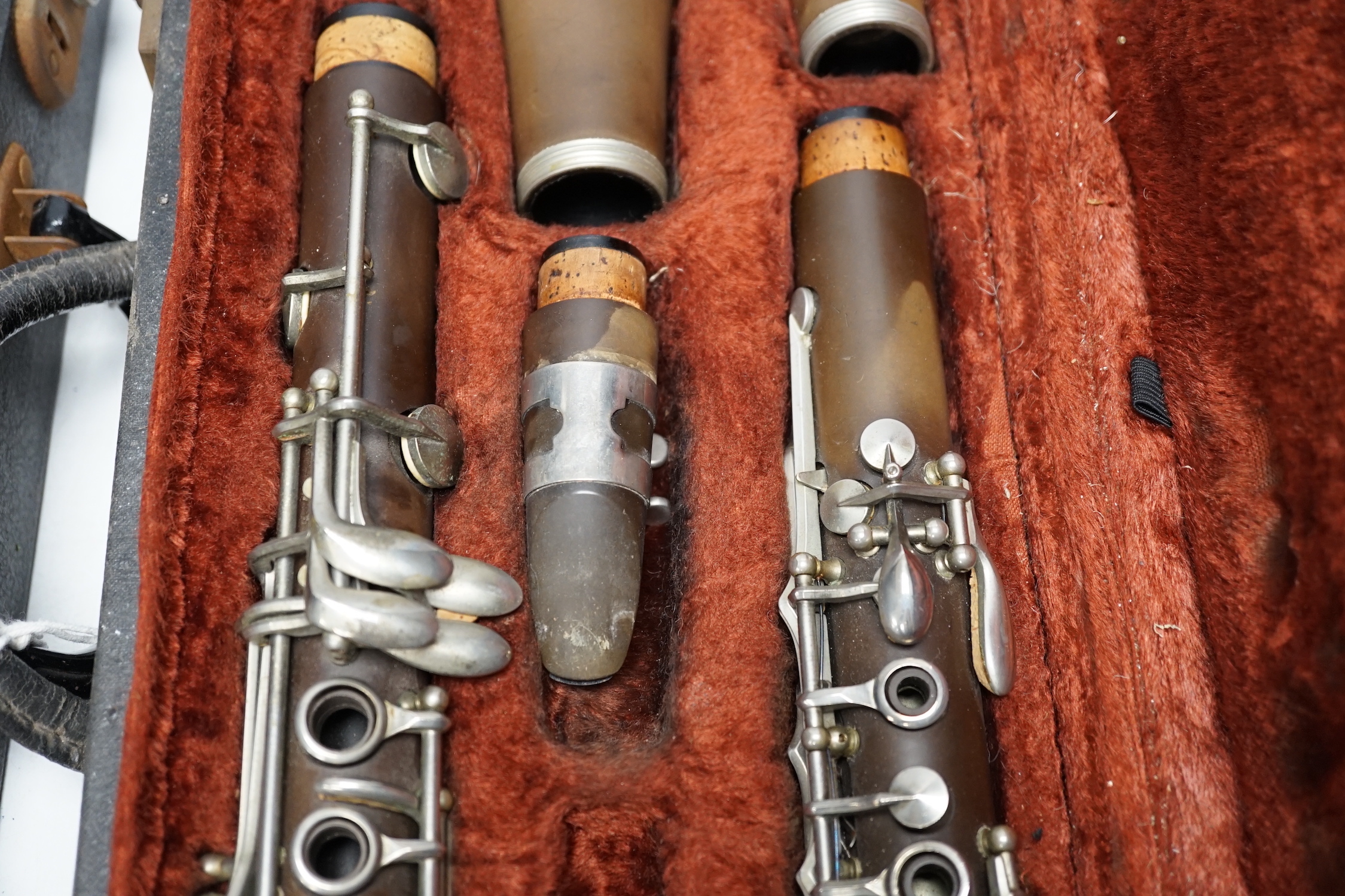 Two cased unmarked clarinets with early key systems, one mid 19th century in rosewood, one with light brown Bakelite body